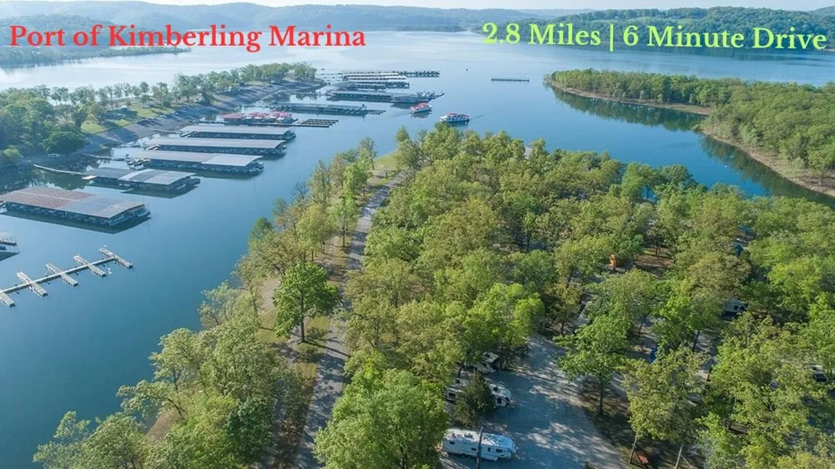 A peaceful lakeside marina scene with docks stretching into the calm water, a tree-lined shore, and hints of a camping area. The gentle evening light adds a sense of relaxation and connection to the outdoors.